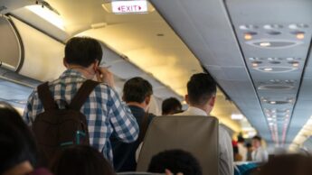 Passageiros de pé no corredor do avião